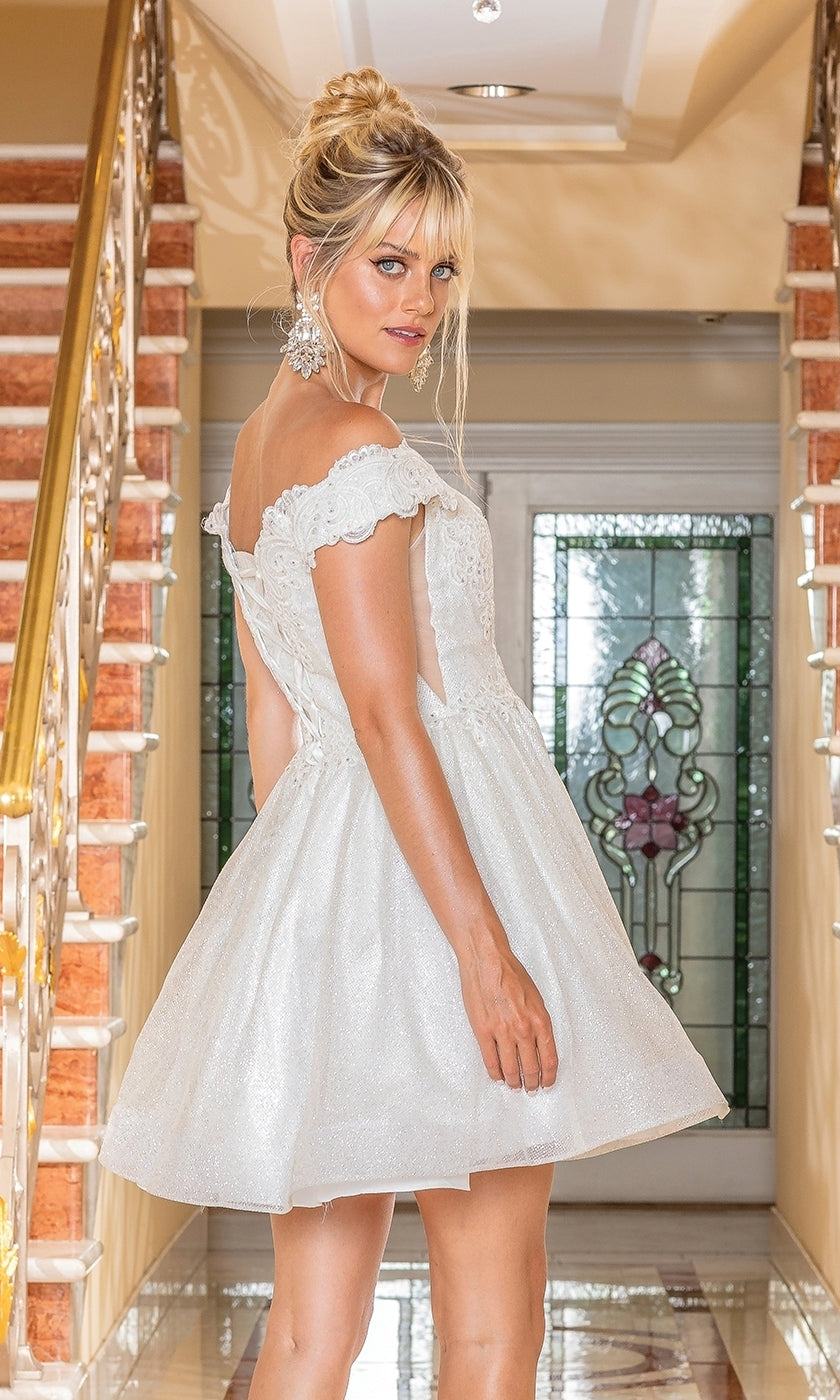 A woman stands on a staircase, looking over her shoulder in the Off-the-Shoulder Short Pastel Hoco Dress 3292, featuring delicate lace details.